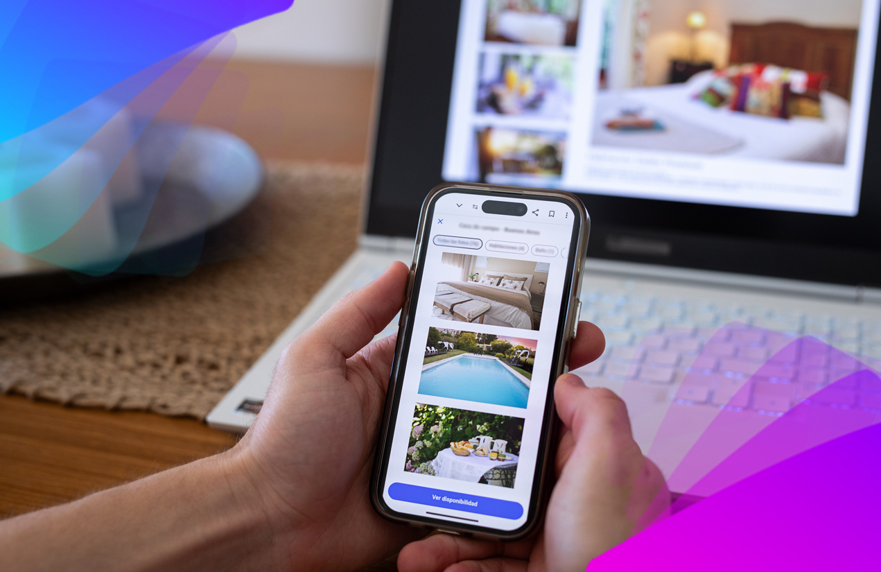 A man holding a phone looking at images of hotels